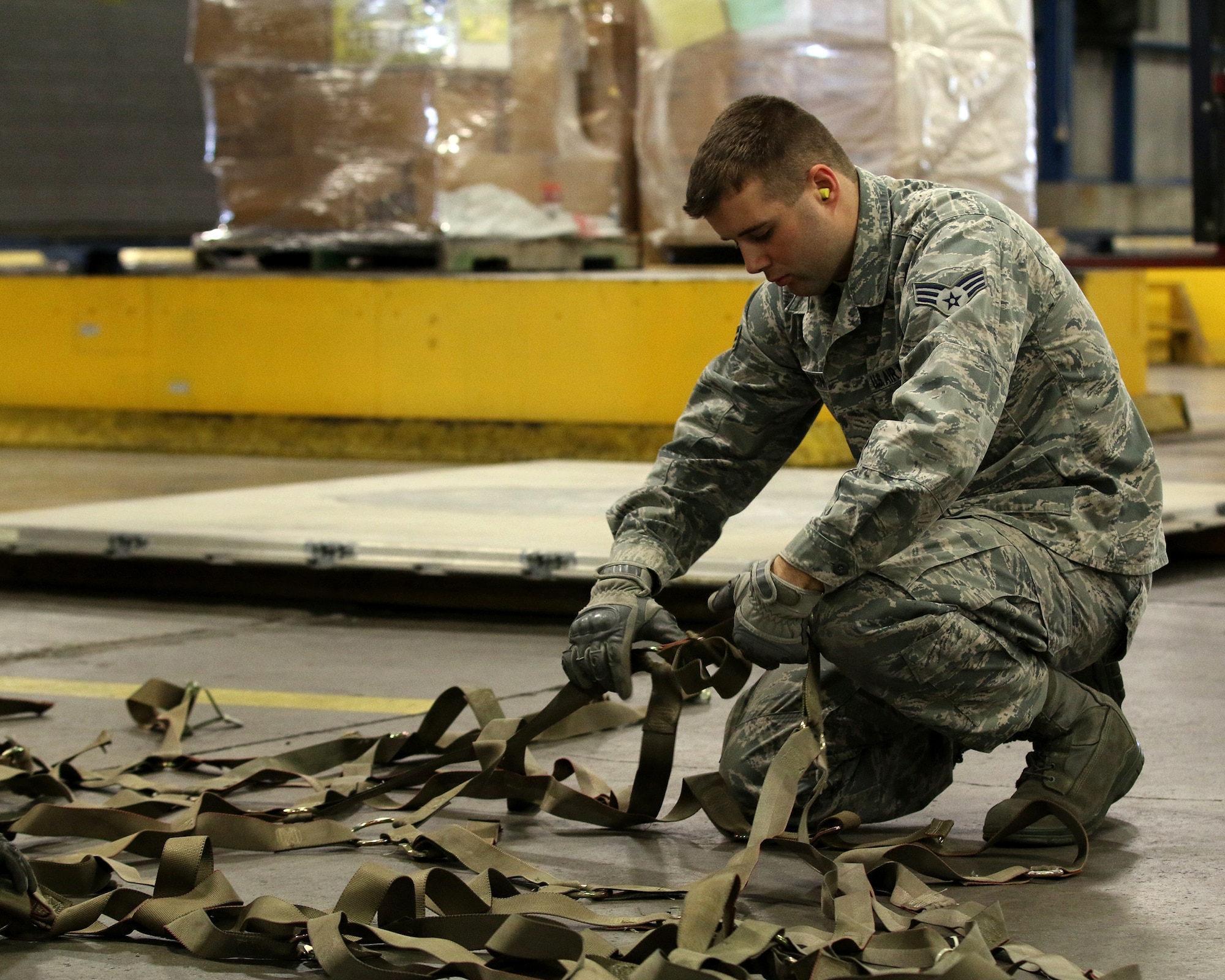 WRIGHT-PATTERSON AIR FORCE BASE, Ohio – Senior Airman Kasch M. McInnis, 87th Aerial Port Squadron air transportation apprentice, prepares cargo straps for pallets simulated for transportation by a C-17 Globemaster III during training held on the Nov. 6, 2015 unit training assembly. (U.S. Air Force photo /Tech. Sgt. Patrick O’Reilly)