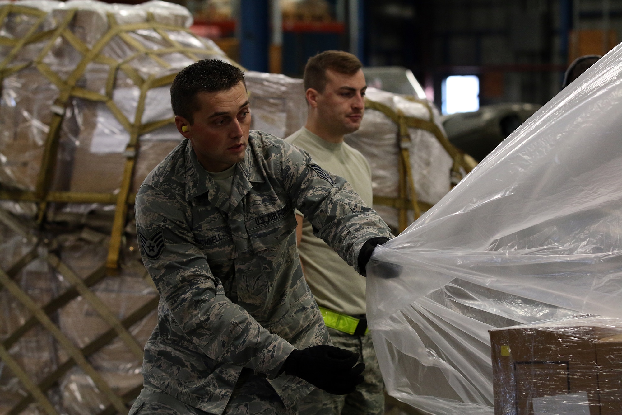 WRIGHT-PATTERSON AIR FORCE BASE, Ohio – Staff Sgt. Andrew Schnell, 87th Aerial Port Squadron cargo processor, applies a plastic covering onto secured pallets simulated for transportation by C-17 Globemaster III during training held on the Nov. 6, 2015 unit training assembly. (U.S. Air Force photo /Tech. Sgt. Patrick O’Reilly))