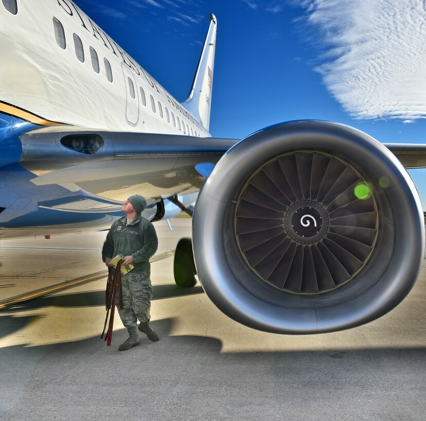 Senior Airman Colby Cannizzaro, 932nd Airlift Wing crew chief with the C-40C walks around the aircraft collecting the Remove Before Flight warning tags during a pre-departure visual inspection, Nov. 20, 2015, Scott Air Force Base, Illinois.  (U.S. Air Force photo by Christopher Parr)


