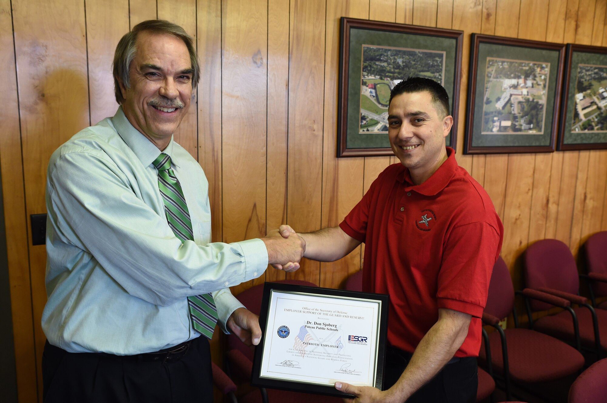 Dr. Don Sjoberg, superintendent of Poteau Public Schools, accepts the Employer Support of the Guard and Reserve Patriot Award Nov. 10, 2015, from 2nd Lt. Alcides Silva, 188th Force Support Squadron personnel officer and Poteau High School teacher, at Poteau, Okla. Sjoberg received the award for contributing to national security and protecting liberty and freedom by supporting employee participation in America’s National Guard and Reserve force as a patriotic employer. (U.S. Air National Guard photo by Tech Sgt. Chauncey Reed/Released)