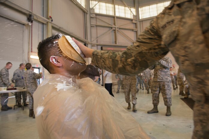 Senior Airman Kevin Medina Echeverria, 437th Aircraft Maintenance Squadron electrical environment specialist, gets “pied” at the 437th AMXS Thanksgiving potluck in Hangar 2 on Joint Base Charleston – Air Base, S.C., on Nov. 19, 2015. Getting “pied” helped raise almost $350.00 for the 437th AMXS’ Christmas party. (U.S. Air Force photo/Airman 1st Class Thomas T. Charlton)