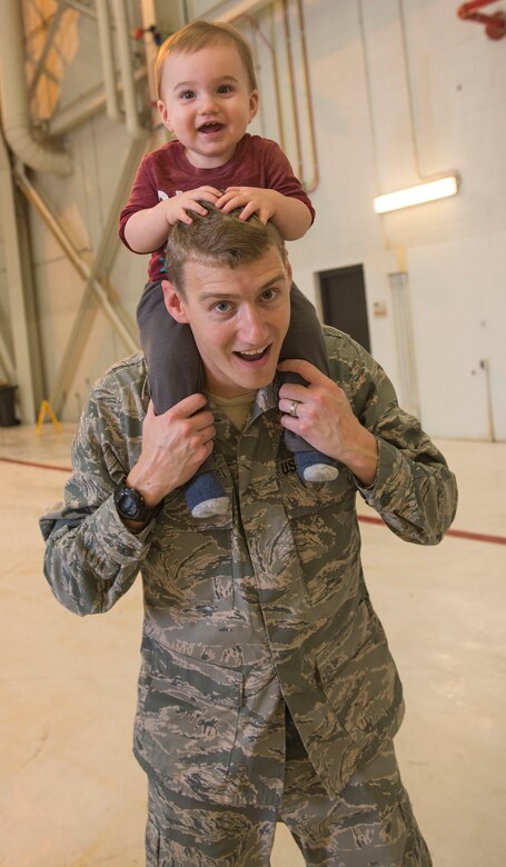 Captain Dave Sustello, 437th Aircraft Maintenance Squadron maintenance operations officer, enjoys the 437th AMXS Thanksgiving potluck with Connor, his son, in Hangar 2 at Joint Base Charleston – Air Base, S.C., on Nov. 19, 2015. Sustello helped contribute to the fundraiser by shoving a pie into CMSgt. Darrell Amoruso, 437th AMXS superintendent’s, face. (U.S. Air Force photo/Airman 1st Class Thomas T. Charlton)