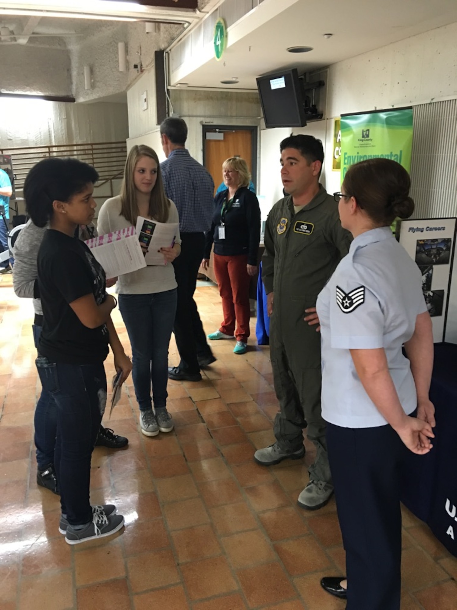 Tech. Sgt. Alejandro Medina, 60th Maintenance Squadron inspection section aircraft manager, and Staff Sgt. BreAnn Hill, 361st Recruiting Squadron recruiter, speak to students at Lindbergh High School in Seattle during the school’s career fair Oct. 21, 2015. (U.S. Air Force photo)
