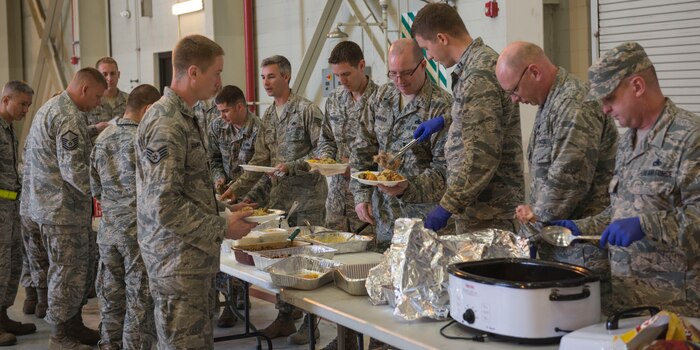 The 437th Aircraft Maintenance Squadron enjoys their Thanksgiving potluck in Hangar 2 at Joint Base Charleston – Air Base, S.C., on Nov. 19, 2015. Since the 437th AMXS is a 24/7 base operations unit, they held three different potlucks to ensure members of all three work shifts could have a Thanksgiving celebration. (U.S. Air Force photo/Airman 1st Class Thomas T. Charlton)