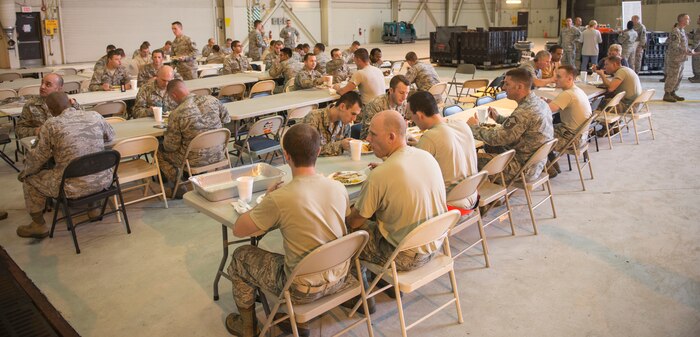 The 437th Aircraft Maintenance Squadron enjoys their Thanksgiving potluck in Hangar 2 at Joint Base Charleston – Air Base, S.C., on Nov. 19, 2015. Since the 437th AMXS is a 24/7 base operations unit, they held three different potlucks to ensure members of all three work shifts could have a Thanksgiving celebration. (U.S. Air Force photo/Airman 1st Class Thomas T. Charlton)