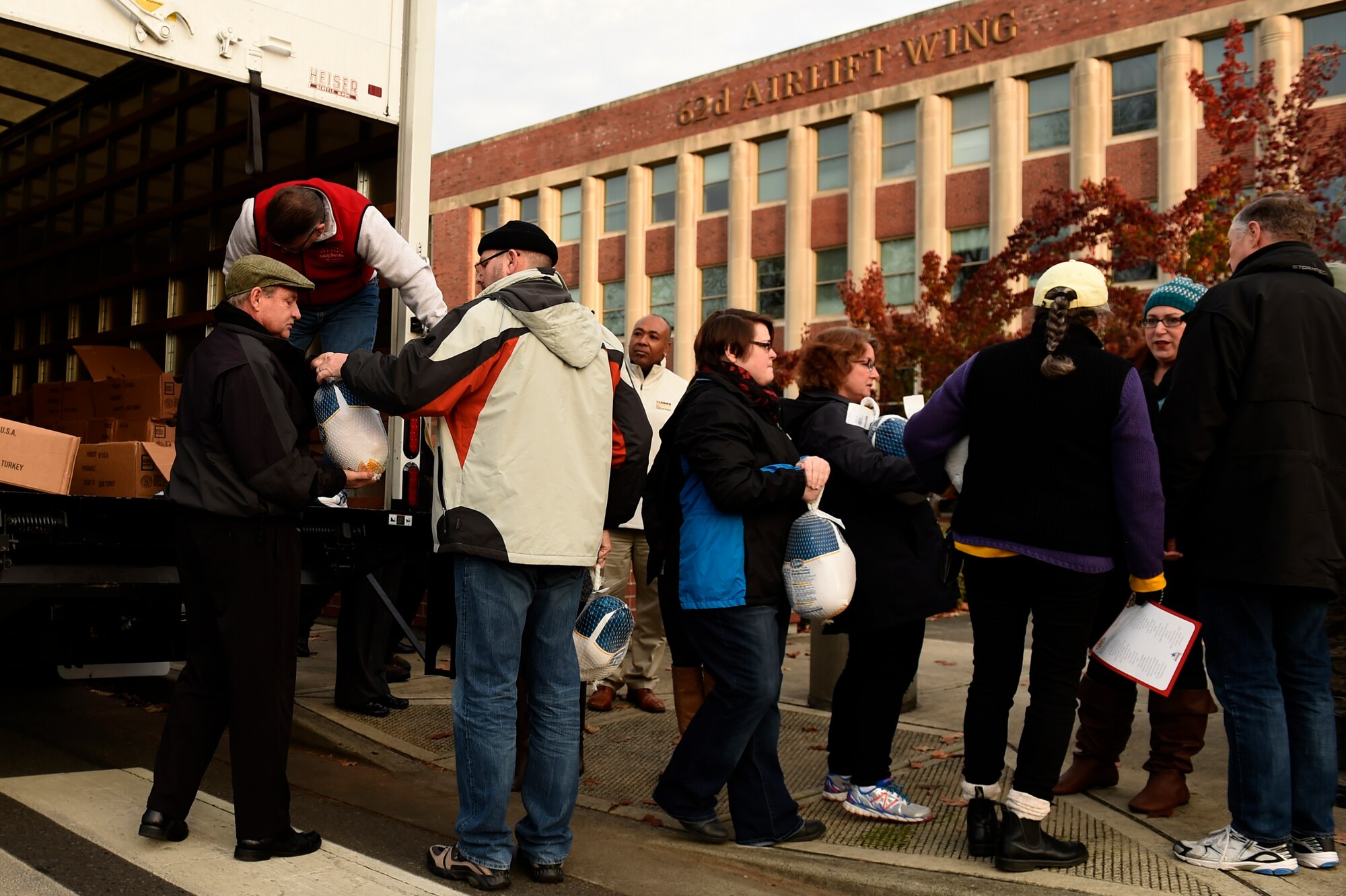 As part of Operation Turkey Drop, local community members hand off donated turkeys to McChord leadership in front of the 62nd Airlift Wing headquarters building at Joint Base Lewis-McChord, Wash., Nov. 22, 2015. Each year more than 20 civic leaders visit JBLM to donate turkeys to the service members so they can have a Thanksgiving meal. (U.S. Air Force photo/Tech. Sgt. Tim Chacon)