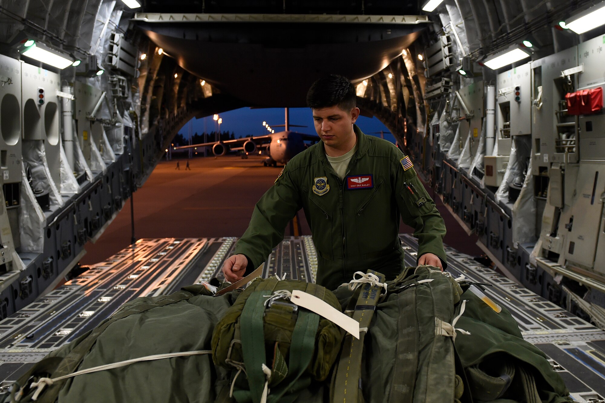 Staff Sgt. Eric Bailey, 62nd Operations Support Squadron joint airdrop inspector, assists with the loading of an air drop bundle Oct. 21, 2015, at Joint Base Lewis-McChord, Wash. Depending on the cargo there can be hundreds of individual ties for the inspectors to inspect, any of which can cause a major malfunction in the load resulting in damage to the cargo, aircraft or personnel. (U.S. Air Force photo by Staff Sgt. Tim Chacon)