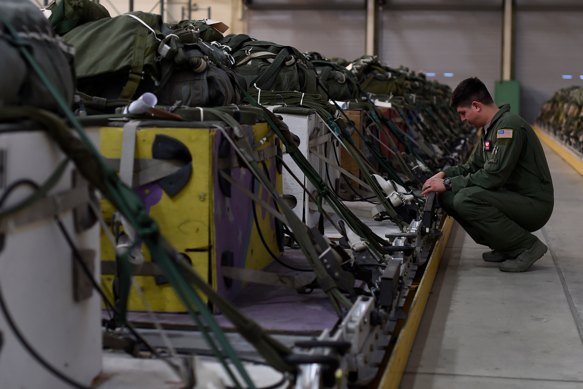 Staff Sgt. Eric Bailey, 62nd Operations Support Squadron joint airdrop inspector, inspects air drop bundles Oct. 21, 2015, at Joint Base Lewis-McChord, Wash. Bailey works in the Joint Inspections office on McChord Field and is one of four people responsible for conducting all the post and pre drop inspections for air drop missions. (U.S. Air Force photo by Staff Sgt. Tim Chacon)