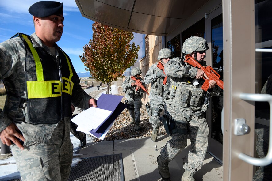 Tech. Sgt. Michael Degennaro (left), 50th Security Forces Squadron, monitors the security forces response during an active shooter exercise Wednesday, Nov. 18, 2015, in the fitness center at Schriever Air Force Base, Colorado.  The exercise’s goal was to ensure the base had the proper techniques, tactics and procedures in place to protect the mission and on base community. (U.S. Air Force photo/Christopher DeWitt)