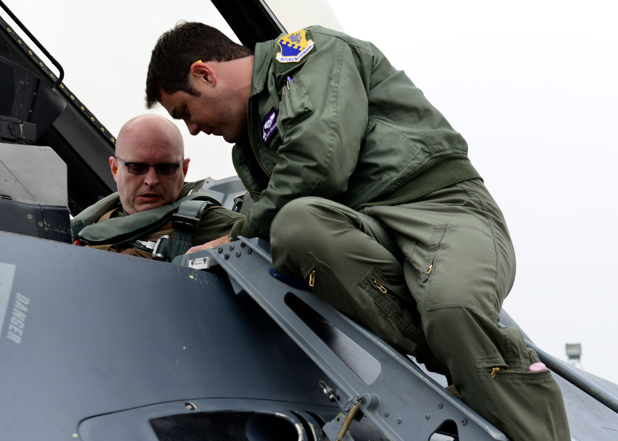 (From right) U.S. Air Force Capt. Matthew Zenishek, 510th Fighter Squadron chief of wing scheduling, explains various features of an F-16 Fighting Falcon cockpit to Ambassador Philip T. Reeker, U.S. Consul General in Milan, Nov. 20, 2015, at Aviano Air Base, Italy. Reeker took a familiarization flight to experience Aviano’s mission first-hand. (U.S. Air Force photo by Airman 1st Class Cary Smith/Released)