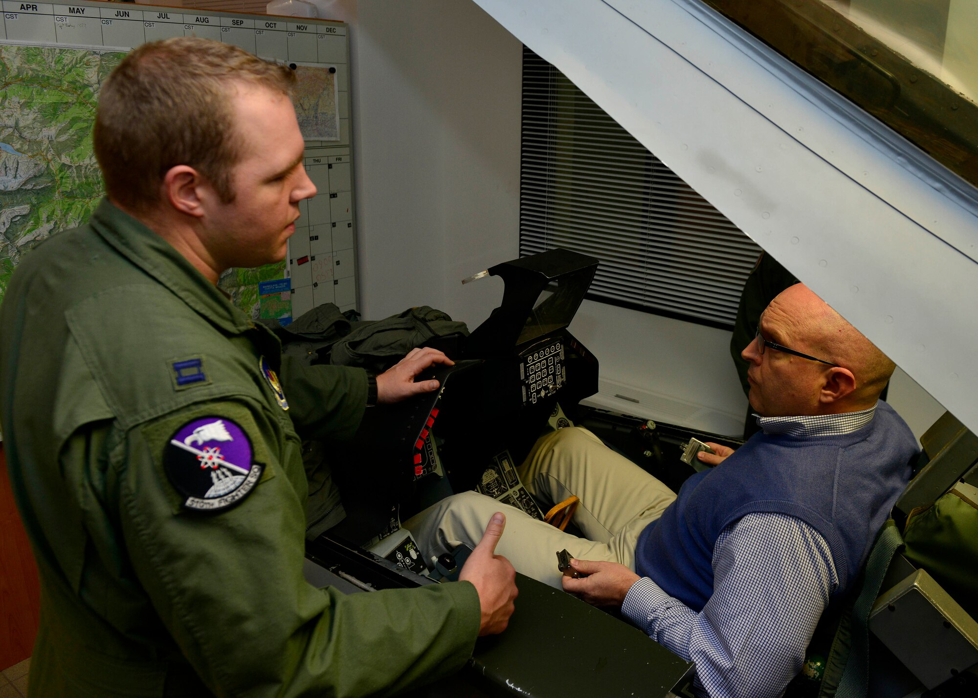 (From left) U.S. Air Force Capt. Matthew Wetherbee, 510th Fighter Squadron flight scheduler, instructs Ambassador Philip T. Reeker, U.S. Consul General in Milan, on F-16 Fighting Falcon emergency procedures, Nov. 19, 2015, at Aviano Air Base, Italy. Reeker took a familiarization flight to experience Aviano’s mission first-hand. (U.S. Air Force photo by Airman 1st Class Cary Smith/Released)