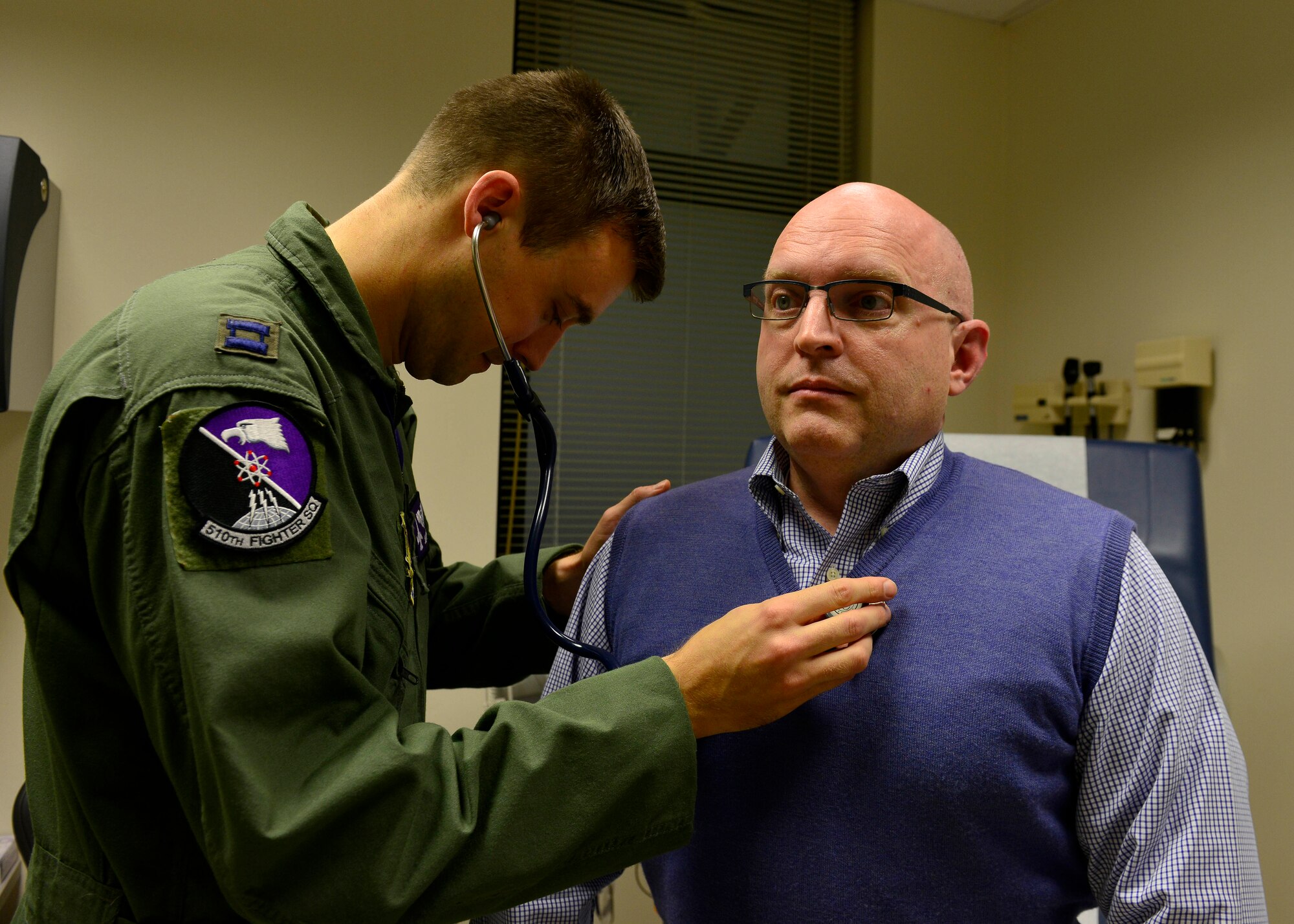 (From left) U.S. Air Force Capt. Jeffrey Kinard, 510th Fighter Squadron flight surgeon, performs a medical check on Ambassador Philip T. Reeker, U.S. Consul General in Milan, Nov. 19, 2015, at Aviano Air Base, Italy. Reeker took a familiarization flight to experience Aviano’s mission first-hand. (U.S. Air Force photo by Airman 1st Class Cary Smith/Released)
