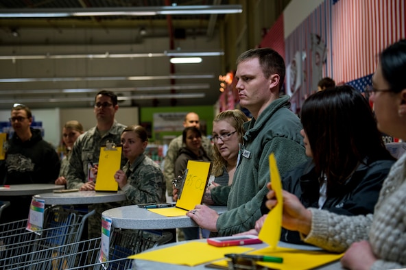 Event participants hold a piece paper with a price on it during the 2015 Commissary Sweep at Spangdahlem Air Base, Germany, Nov. 23, 2015. The event allowed the contestants to shop for groceries, solve riddles and have fun. (U.S. Air Force photo by Senior Airman Rusty Frank/Released)