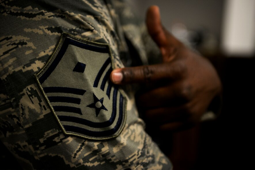 U.S. Air Force Master Sgt. Daryl Allen, the 509th Aircraft Maintenance Squadron first sergeant, shows children his first sergeant insignia during Operation Spirit at Whiteman Air Force Base, Mo., Nov. 21, 2015. Allen told children to look for the diamond if they need any assistance during their simulated deployment. (U.S. Air Force photo by Senior Airman Sandra Marrero) 