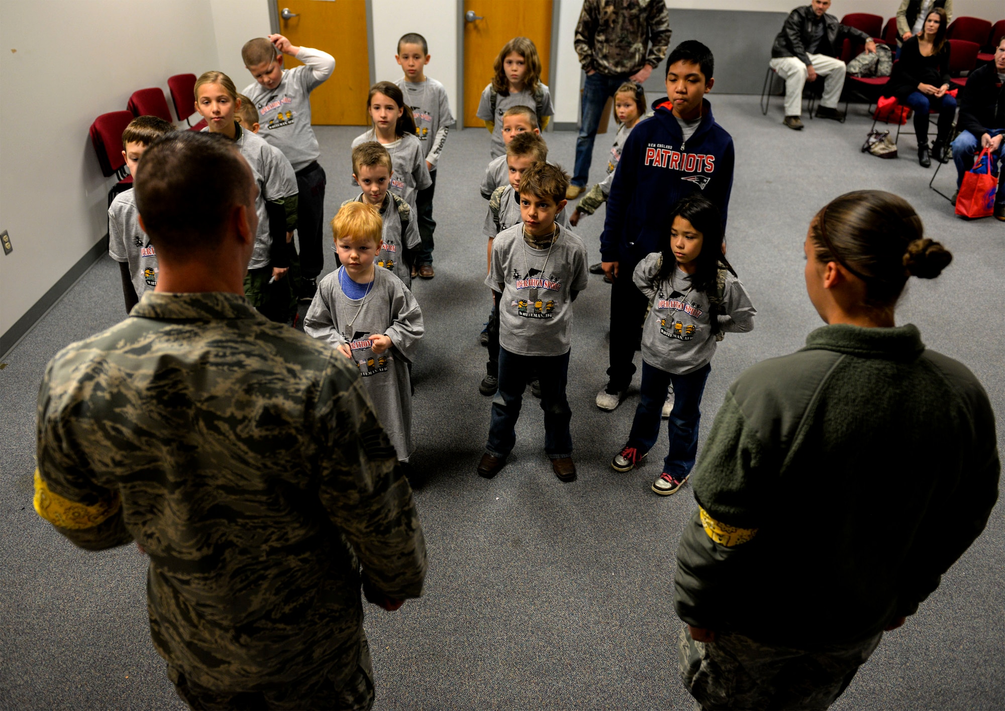 U.S. Air Force Tech. Sgt. John Arnio, left, and Senior Airman Devin Pope, 509th Security Forces Squadron training instructors, lead a formation of children during Operation Spirit at Whiteman Air Force Base, Mo., Nov. 21, 2015. Operation Spirit is an annual event that informs children and families by taking them through a simulated deployment process. (U.S. Air Force photo by Senior Airman Sandra Marrero)