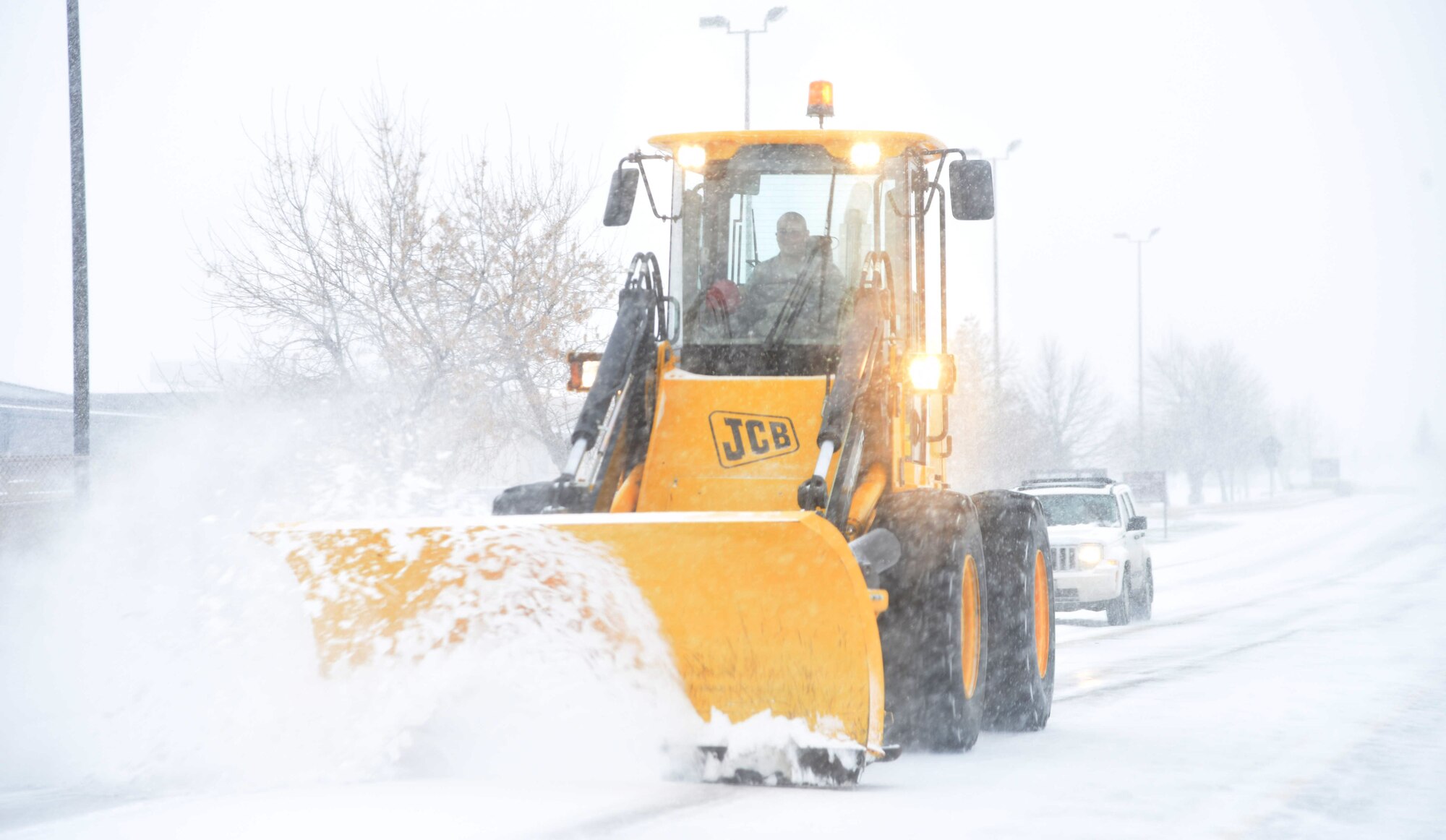 A member of the 341st Civil Engineer Squadron at Malmstrom Air Force Base, Mont., plows a road Nov. 24, 2015, at the beginning of the snowfall season. To accomplish the mission of maintaining safe driving conditions on Malmstrom during the winter, 341st CES squadron personnel utilize 19 pieces of heavy equipment dedicated to snow removal. (U.S. Air Force photo/Airman Collin Schmidt)