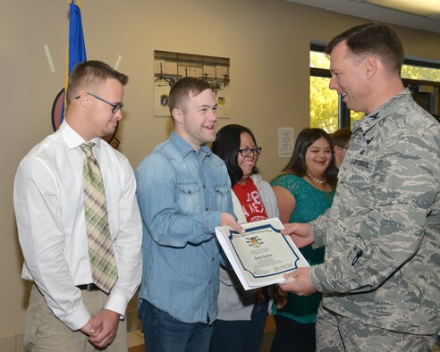 58th Special Operations Wing Commander Col. Dagvin Anderson, right, gives an honorary warrior certificate to James Keefner, a student at Jeremiah’s Place. The certificates were presented to eight students at the promotion ceremony for 58th SOW member 1st Lt. Eddie Cruz. (Photo by Jamie Burnett)