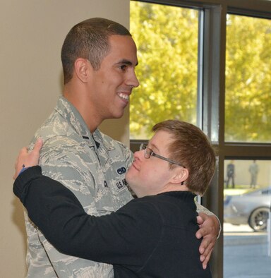 1st Lt. Eddie Cruz of the 58th Special Operations Wing, left, hugs Chris Logan of  Jeremiah’s Place school at his promotion ceremony Friday. Cruz included students from  the school for young people with developmental disabilities in his ceremony. (Photo by Jamie Burnett)