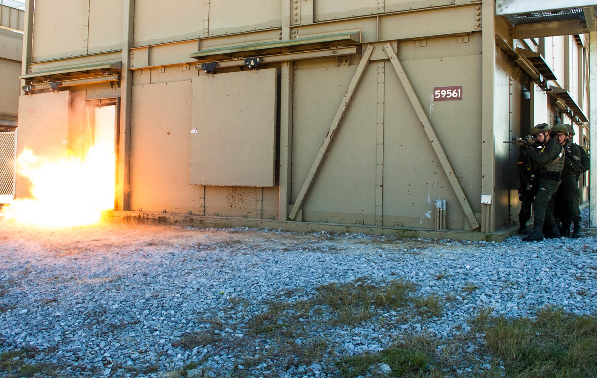 Members of the Colombian Compañía Jungla Antinarcóticos stage to assault the entryway of an Eglin Air Force Base shoot house as an explosive door-breaching charge detonates during a live-fire joint training exercise on November 20.  The Junglas, as they are known, are training with the Special Forces soldiers on Eglin Air Force Base as part of the Western Hemisphere’s longest enduring security partnership formed to counter narcotic and human trafficking. (U.S. Army photo/Maj. Thomas Cieslak)