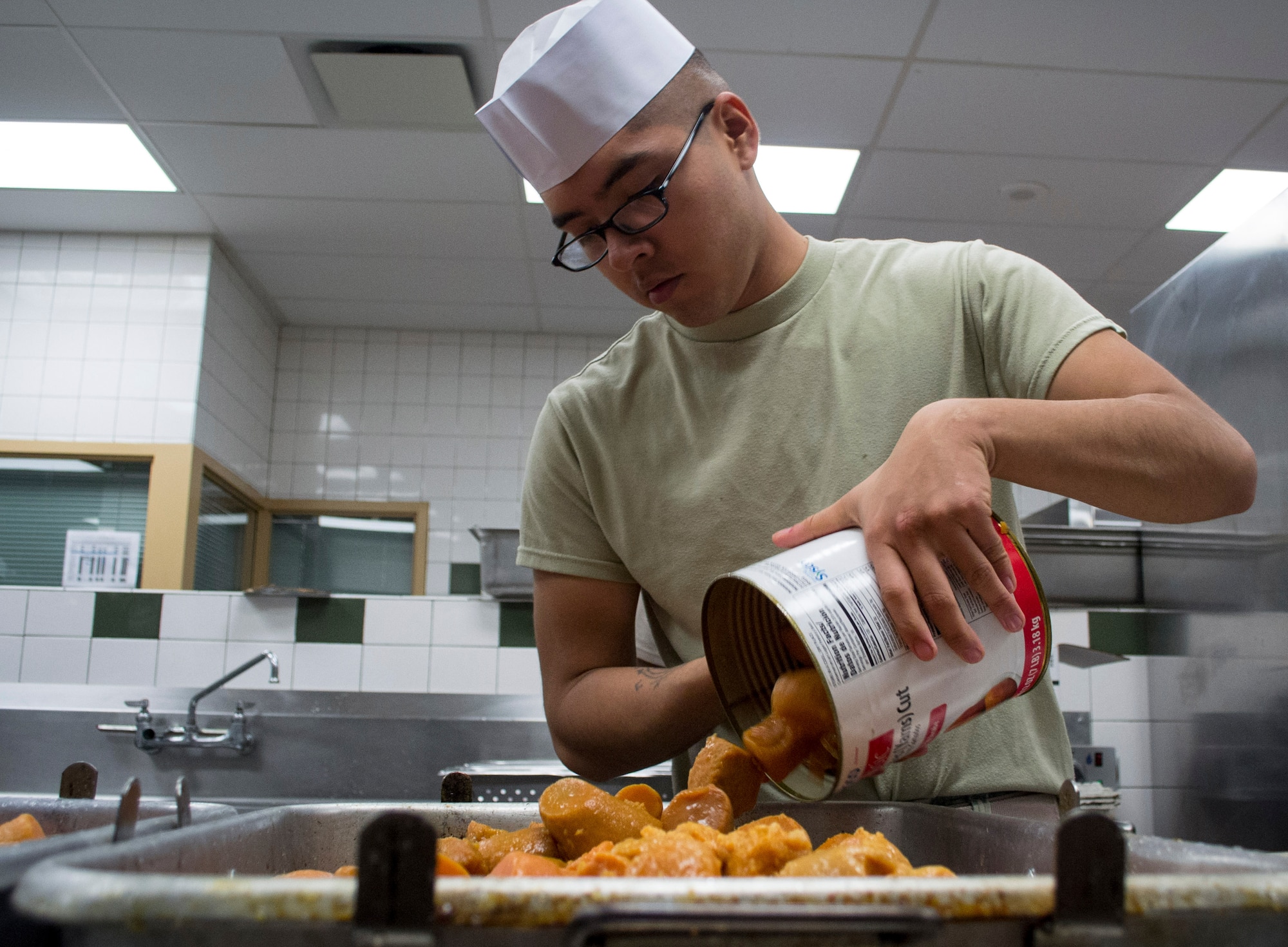 A culinary specialist assigned to the 7th Special Forces Group (Airborne) prepares sweet potatoes for baking as he and others prepare a Thanksgiving meal in the unit’s dining facility November 23.  The group’s culinary specialist team prepared over 600 pounds of turkey, 115 pounds of steamship round and 184 pounds of ham for serving to the group’s soldiers, families and friends. (U.S. Army photo/Maj. Thomas Cieslak)