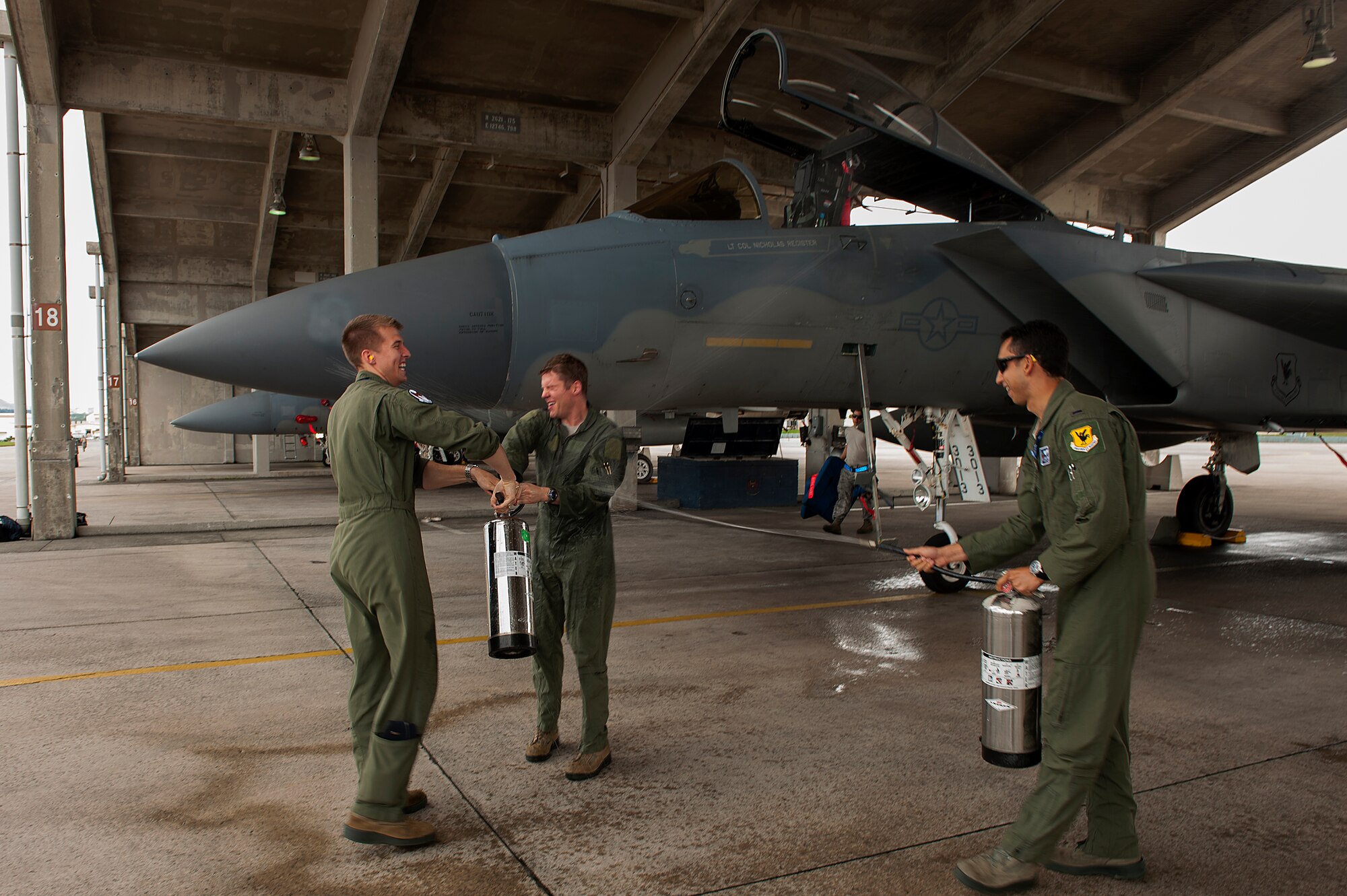 U.S. Air Force Lt. Col. Alexander Haddad, 44th Fighter Squadron pilot, gets sprayed with water by 1st Lt. Maxwell Anthony (left) and 1st Lt. Michael Tope (right), 44th FS pilots, after Haddad reached 2,000 flying hours, Nov. 19, 2015, at Kadena Air Base, Japan. It is a tradition for pilots to get sprayed down with water after reaching a significant milestone.. (U.S. Air Force photo by Airman 1st Class Corey M. Pettis)