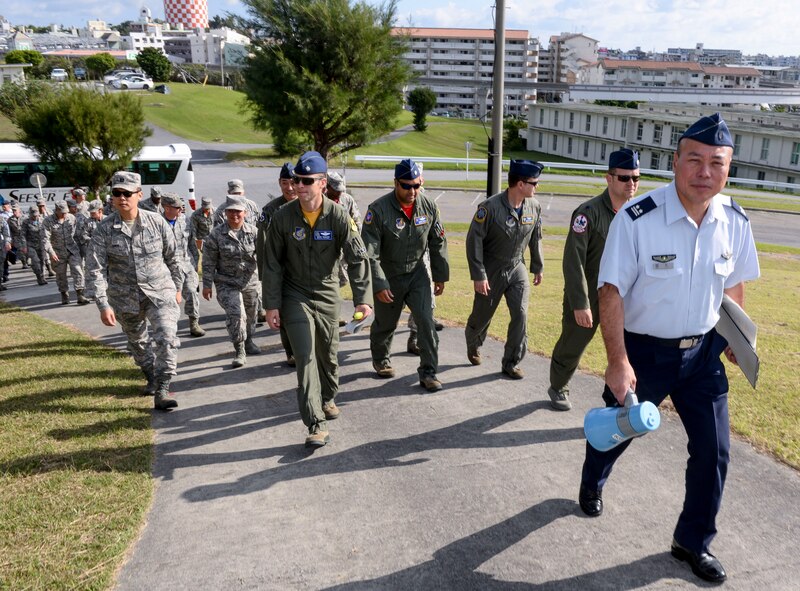 Japan Air Self-Defense Force Lt. Col. Yutaka Hori, 83rd Wing Headquarters director of administration, leads Kadena Airmen up a hill to observe a historical site Nov. 20, 2015, at Naha Air Base, Japan. The U.S. Airmen were provided an extensive tour of the base as part of a wing exchange program, held to improve the understanding of each Air Force’s mission and capabilities. (U.S. Air Force photo by Senior Airman John Linzmeier)  