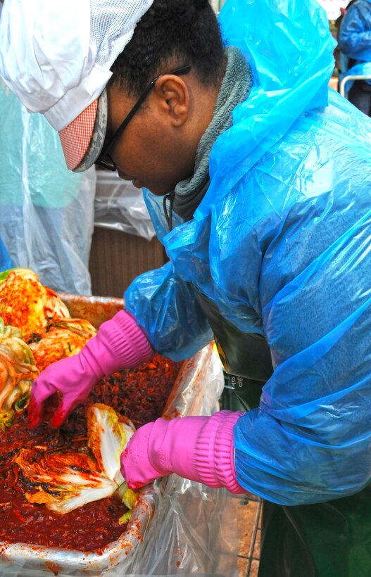 Volunteers from the U.S. Army Corps of Engineers' Far East District volunteered to help make kimchi on one brisk November day. Lt. Col. Timika Wilson, deputy commander of the Far East District, turns a cabbage into kimchi by stuffing it with a spicy paste.