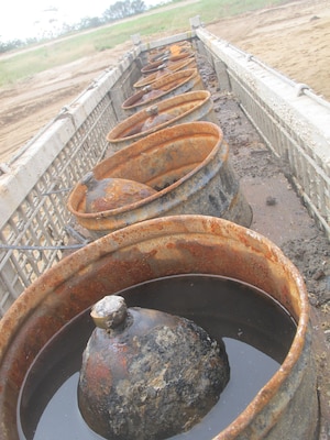 A row of 6.4-inch Brooke shells wait in buckets filled with seawater prior to being inerted, Nov. 4. Technicians inerted 170 Brooke shells and Dahlgren projectiles in two months. 