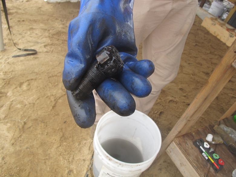 Matt Christiansen, a former Navy explosive ordnance disposal technician who functioned as the safety officer for the project, holds a fuse that was removed from a 6.4-inch Brooke shell projectile. Christiansen was part of a MuniRem team that inerted 170 projectiles from the CSS Georgia between September and November.