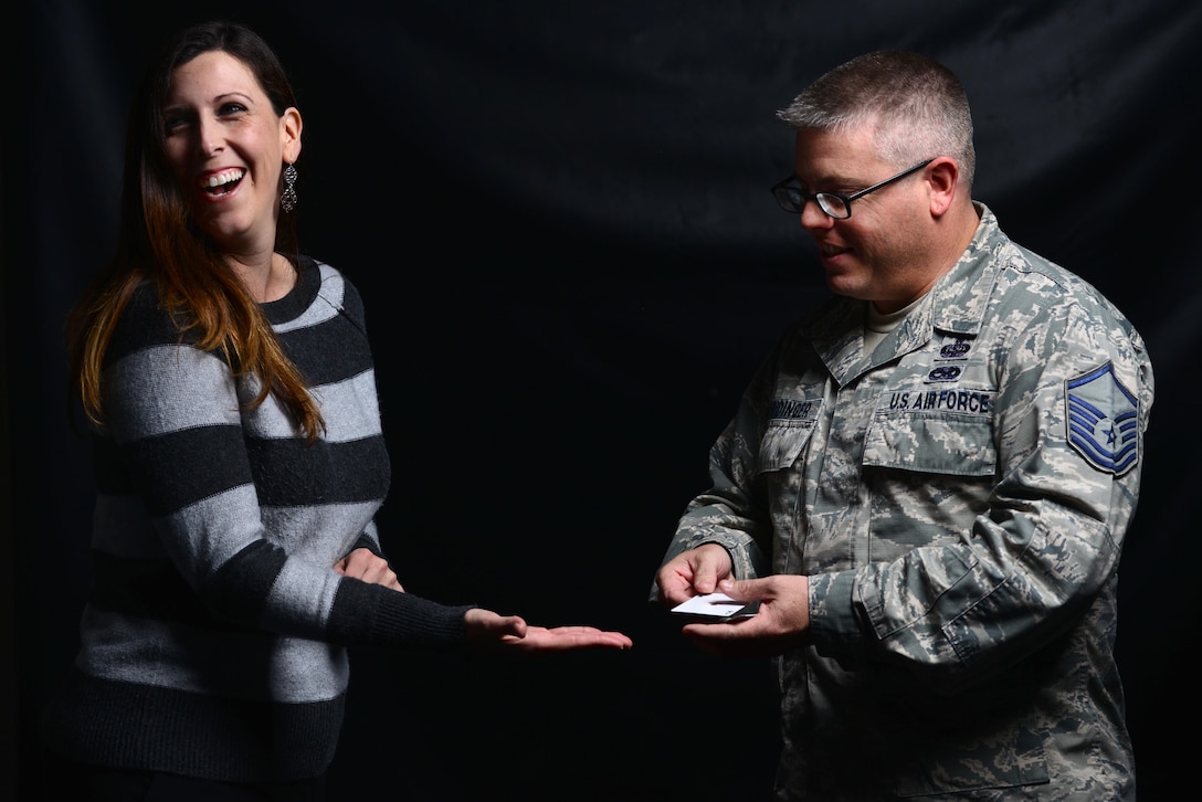 Alisa Deuermeyer, a volunteer at Joint Base Langley-Eustis, Va., laughs as U.S. Air Force Master Sgt. Scott Fridinger, additional duty first sergeant assigned to the Air Combat Command Communications Support Squadron, performs a card trick at Langley Air Force Base, Va., Oct. 21, 2015. U.S. Air Force photo by Senior Airman Aubrey White