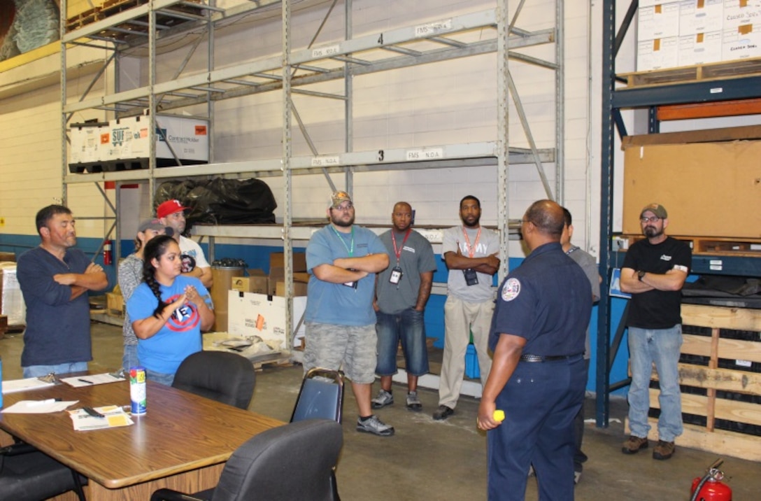 DLA Distribution Corpus Christi, Texas, employees receive a presentation on fire extinguisher training from Naval Air Station fire inspector Maurice Phillips.