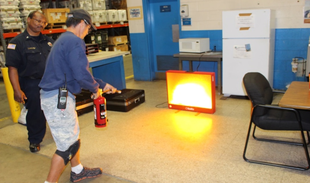 A DLA Distribution Corpus Christi, Texas, employee uses Naval Air Station Fire Department’s fire simulator to practice use of a fire extinguisher.