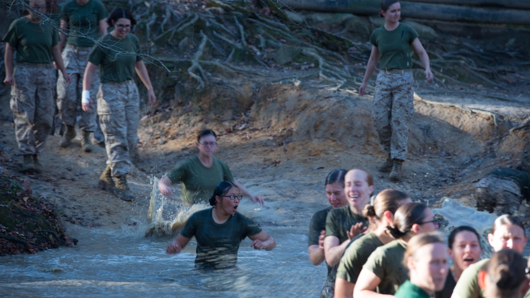 Candidates in Officer Candidate School jump into a muddy pit right before receiving their Eagle, Globe and Anchor at Marine Corps Base Quantico, Virginia, Nov. 20, 2015. The candidates of Class 0CC-220 graduated and were commissioned as second lieutenants during the 75th anniversary of OCS on Brown Field. (U.S. Marine Corps photo by Sgt. Eric Keenan)