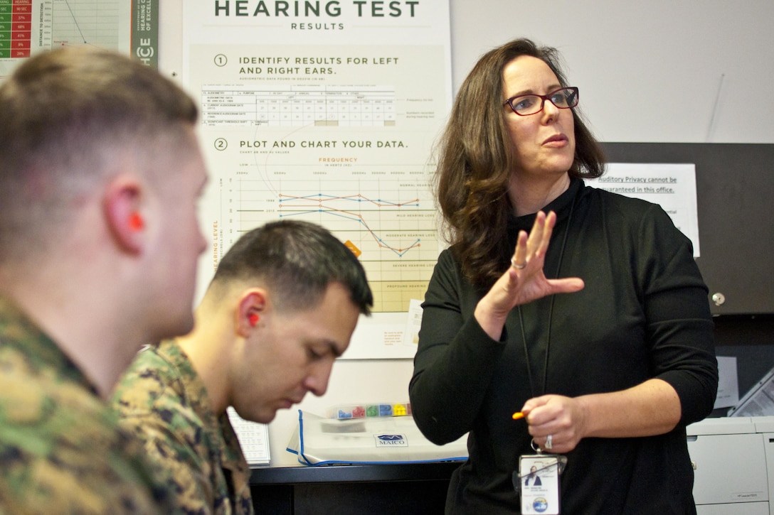 Jolene Mancini, occupational audiologist at Naval Health Clinic Quantico, speak to Cpl. Randell Alexander, left, and Sgt. Oscar Portillo during their post-deployment health assessment, Nov. 20. Both Marines are Marine Corps security guards.