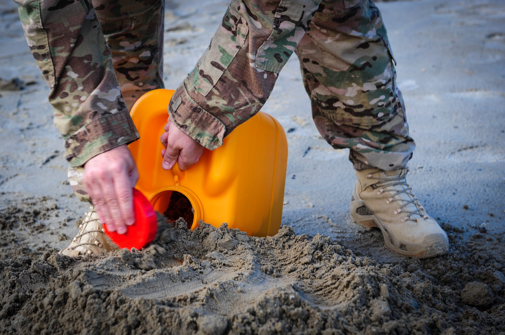 Tech. Sgt. Brian Shepherd, an explosive ordnance disposal craftsman with the 1st Special Operations Civil Engineer Squadron, packs sand into a jug to mimic explosive residue from a partially detonated improvised explosive device at Hurlburt Field, Fla., Nov. 19, 2015. Wood boxes, plastic containers and backpacks are some items that can be used to make an improvised explosive device, as well as multiple types of batteries. (U.S. Air Force photo by Senior Airman Meagan Schutter)