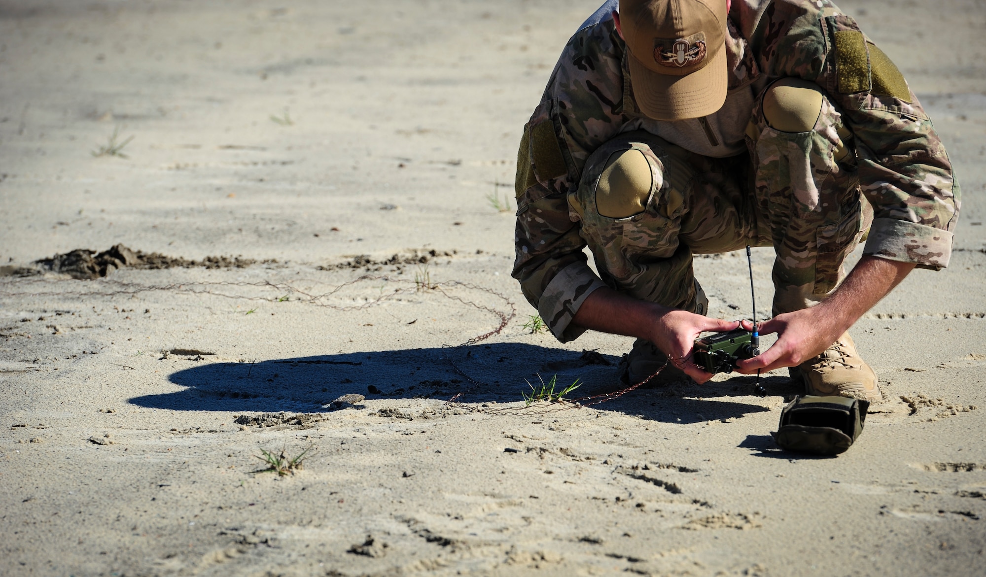 Senior Airman Teddy Compston, an explosive ordnance disposal journeyman with the 1st Special Operations Civil Engineer Squadron, connects blasting wires to a receiver at Hurlburt Field, Fla., Nov. 19, 2015. Wood boxes, plastic containers and backpacks are some items that can be used to make an improvised explosive device, as well as multiple types of batteries. (U.S. Air Force photo by Senior Airman Meagan Schutter)