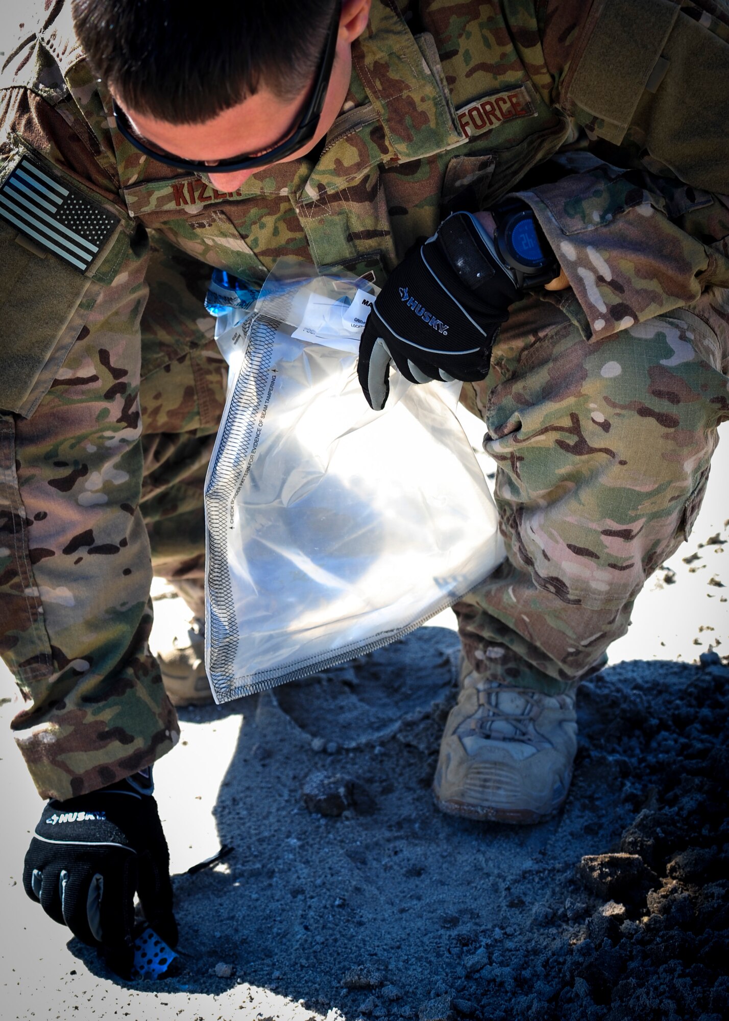Senior Airman Nathaniel Kizer, an explosive ordnance disposal journeyman with the 1st Special Operations Civil Engineer Squadron, collects a cellphone fragment for evidence during  post-blast analysis at Hurlburt Field, Fla., Nov. 19, 2015. A Post-blast analysis takes place when an improvised explosive device detonates and EOD Airmen arrive on scene to determine what happened. (U.S. Air Force photo by Senior Airman Meagan Schutter)