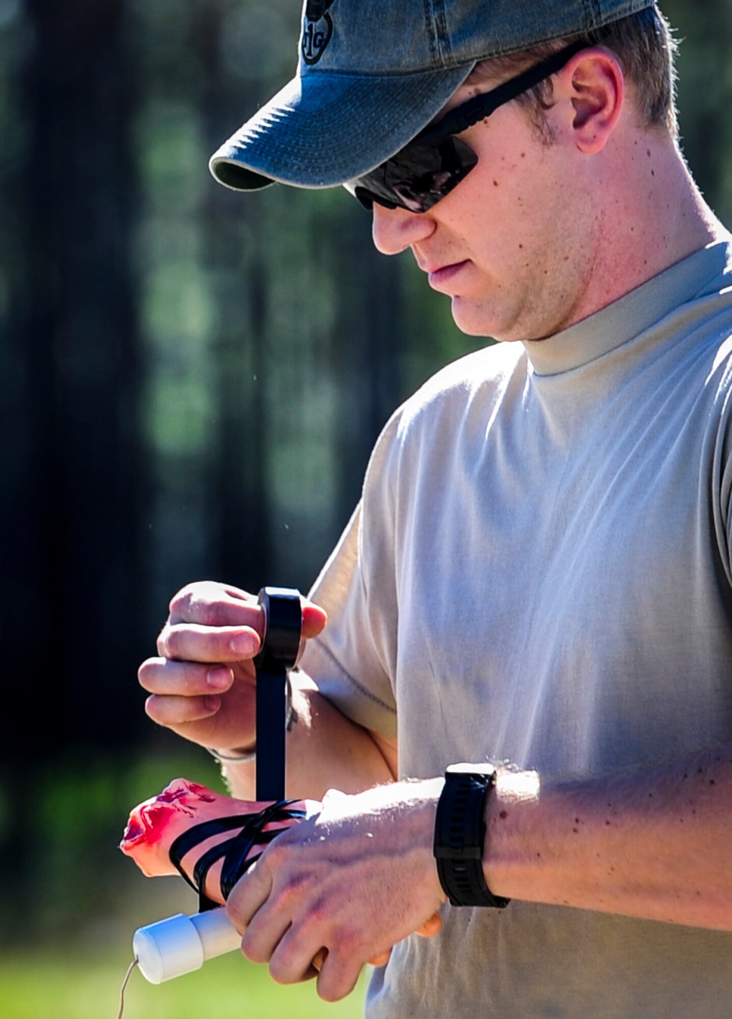 Staff Sgt. Thomas Johnson, an explosive ordnance disposal craftsman with the 1st Special Operations Civil Engineer Squadron, tapes a plastic hand to a trigger at Hurlburt Field, Fla., Nov. 19, 2015. Wood boxes, plastic containers and backpacks are just some items that can be used to make an improvised explosive device, as well as multiple types of batteries. (U.S. Air Force photo by Senior Airman Meagan Schutter)