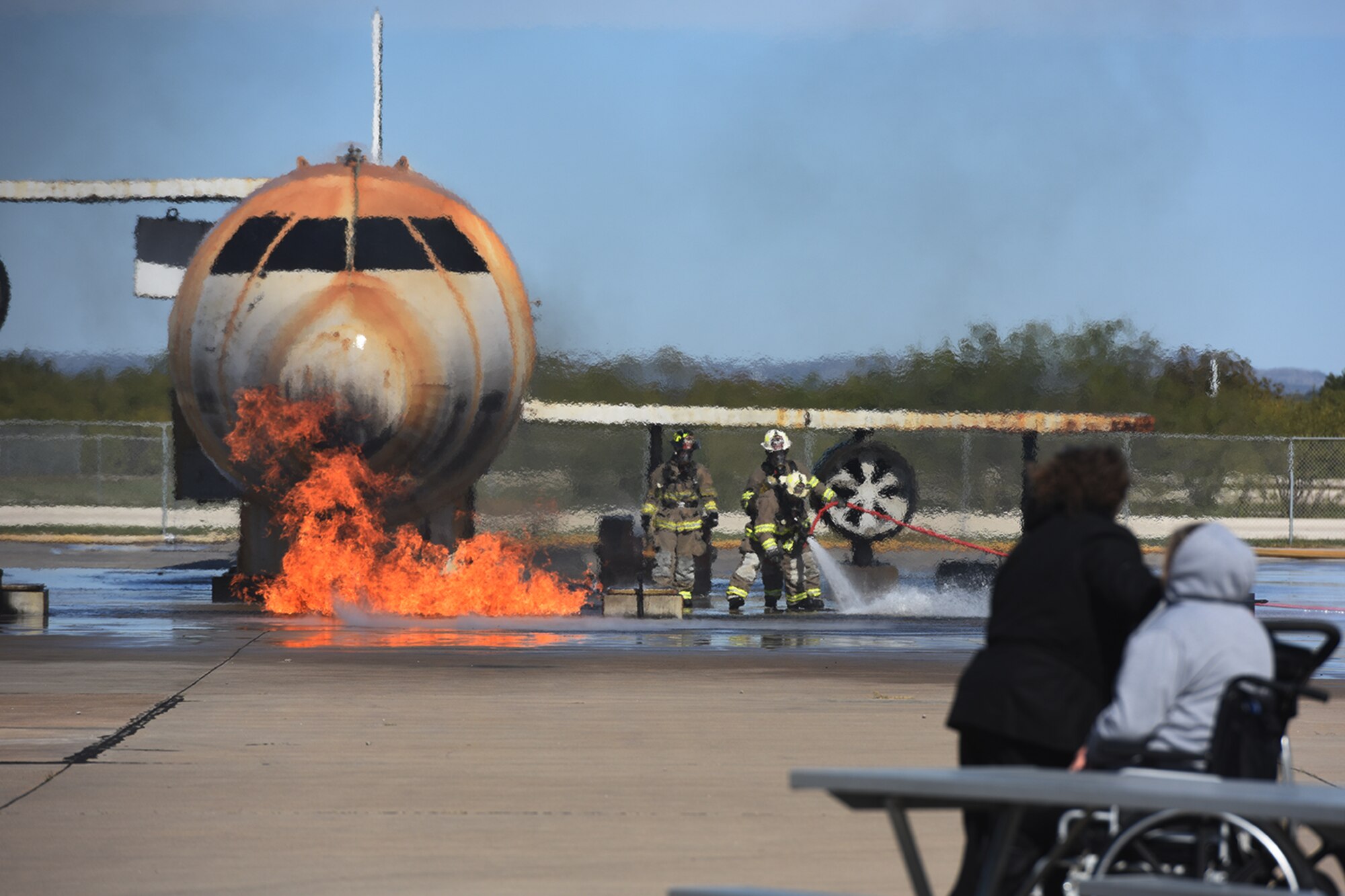 Spectators watched San Angelo Fire Department firefighters extinguish flames during the 7th Annual Goodfellow Community Appreciation Day at the Louis F. Garland Department of Defense Fire Academy training pad on Goodfellow Air Force Base, Texas, Nov. 21, 2015. The San Angelo Fire Department and Goodfellow have a memorandum of understanding authorizing the use of the academy’s training facilities. (U.S. Air Force photo by Staff Sgt. Laura R. McFarlane/Released)