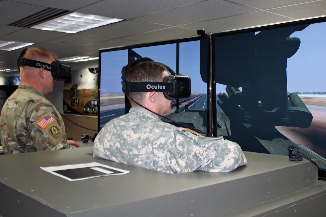 Maj. Mike Stinchfield, left, and Maj. Greg. Pavlichko, demonstrate the virtual capabilities of the Stryker Virtual Collective Trainer concept at the Combined Arms Center - Training Innovation Facility on Fort Leavenworth, Kan.