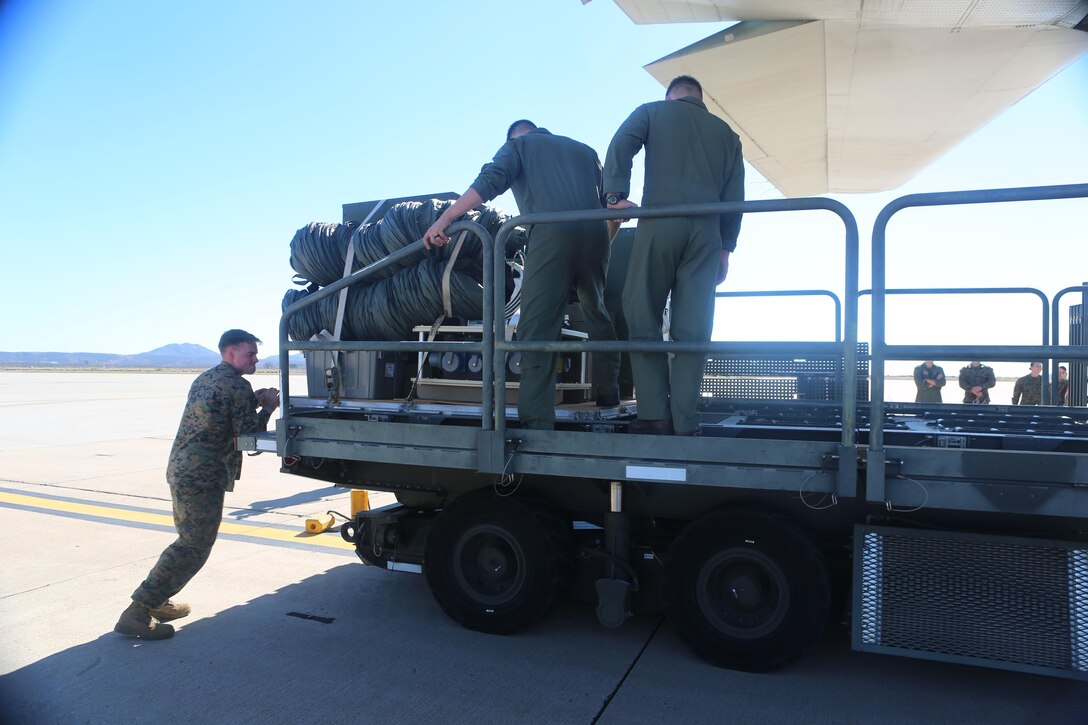 Marines with 3rd Marine Aircraft Wing push the components of the Tactical Imagery Production System onto a KC-130J Super Hercules during a loading exercise aboard Marine Corps Air Station Miramar, Calif., Nov. 20. A TIPS is a highly-mobile, rapidly-deployable, self-contained tactical shelter system with imagery and reproduction capabilities that can be used while deployed in austere conditions.