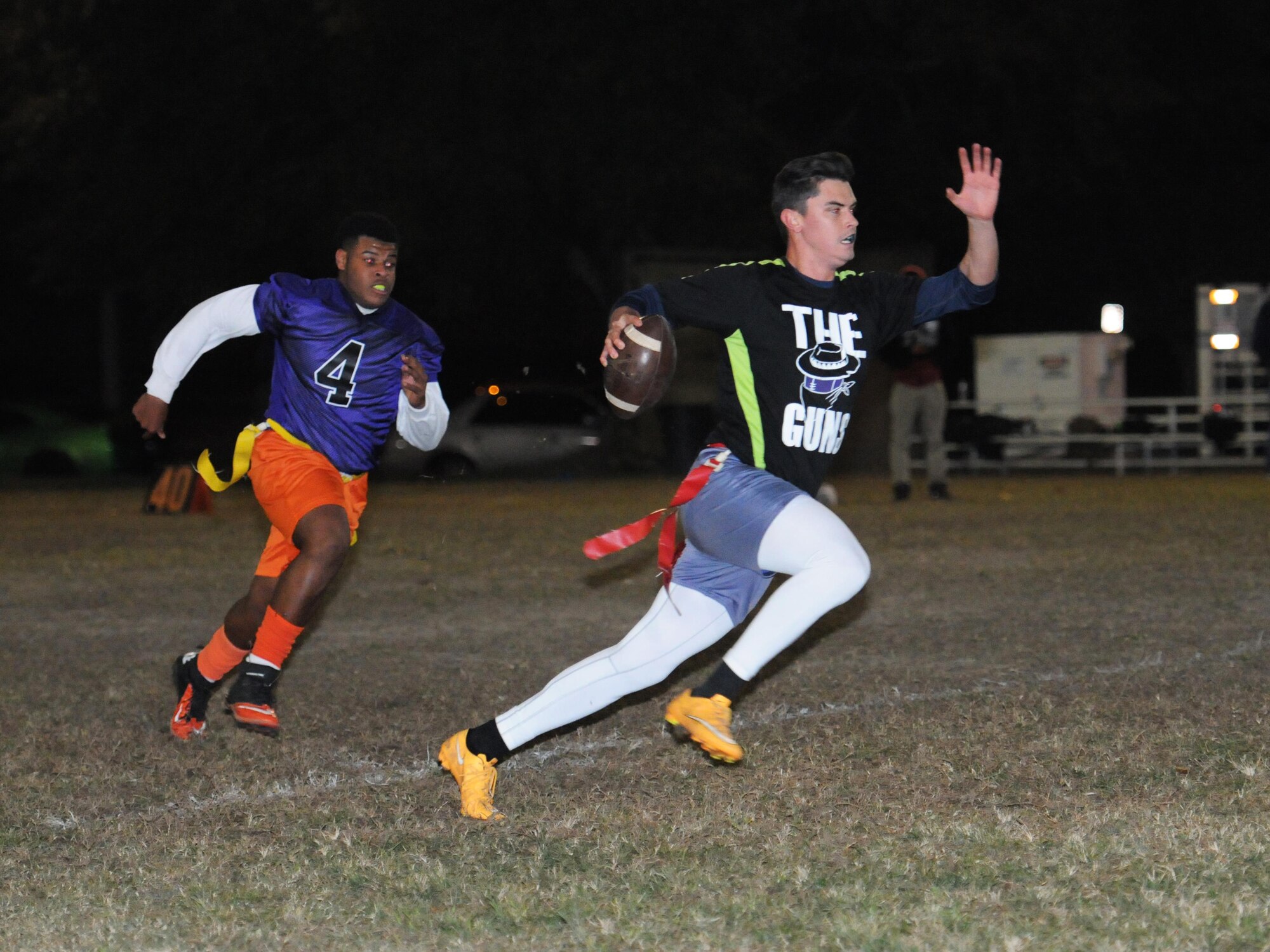 Paul McDonald, son of Tech. Sgt. Larry McDonald, 403rd Maintenance Squadron sheet metal technician, chases Petty Officer 3rd Class Taylor Wells, Naval Mobile Construction Battalion 133rd communications specialist, Gulfport, Miss., during the intramural flag football championship game Nov. 23, 2015, Keesler Air Force Base, Miss. The 403rd Wing defeated NMCB, 30-18. (U.S. Air Force photo by Kemberly Groue)