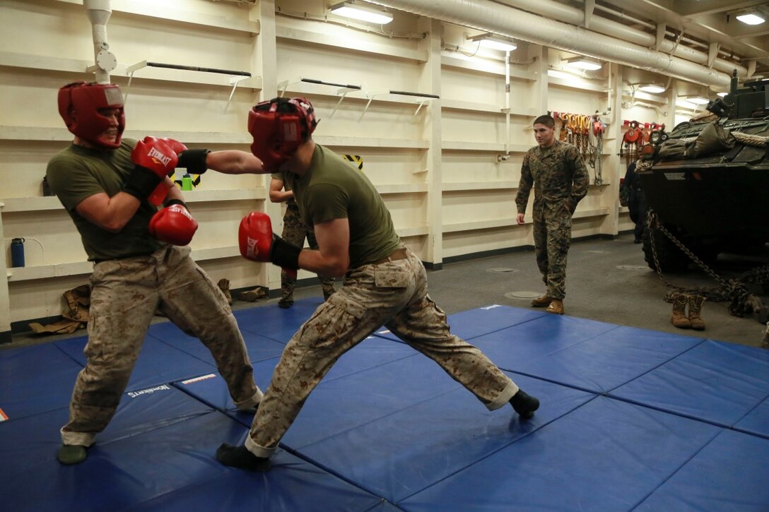 PHILIPPINE SEA (Nov. 23, 2015) U.S. Marine Lance Cpl. Aaron Jones, right, throws a rear-hand punch while sparring aboard the USS Anchorage (LPD 23). Jones is a tank driver with 1st Tanks Detachment, Battalion Landing Team 3rd Battalion, 1st Marine Regiment, 15th Marine Expeditionary Unit. The 15th MEU is currently deployed in the Indo-Asia-Pacific region to promote regional stability and security in the U.S. 7th Fleet area of operations. (U.S. Marine Corps photo by Sgt. Steve H. Lopez/Released)
