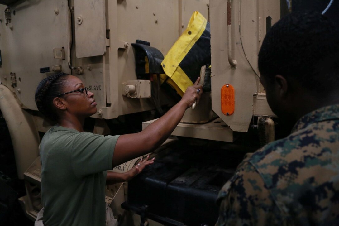 PHILIPPINE SEA (Nov. 23, 2015) U.S. Marine Cpl. LaNita Moss, left, scrubs the rust off a MK25 Medium Tactical Vehicle Replacement during preventive maintenance aboard the USS Anchorage (LPD 23). Moss is a motor transport operator with Combat Logistics Battalion 15, 15th Marine Expeditionary Unit. The 15th MEU is currently deployed in the Indo-Asia-Pacific region to promote regional stability and security in the U.S. 7th Fleet area of operations. (U.S. Marine Corps photo by Sgt. Steve H. Lopez/Released)