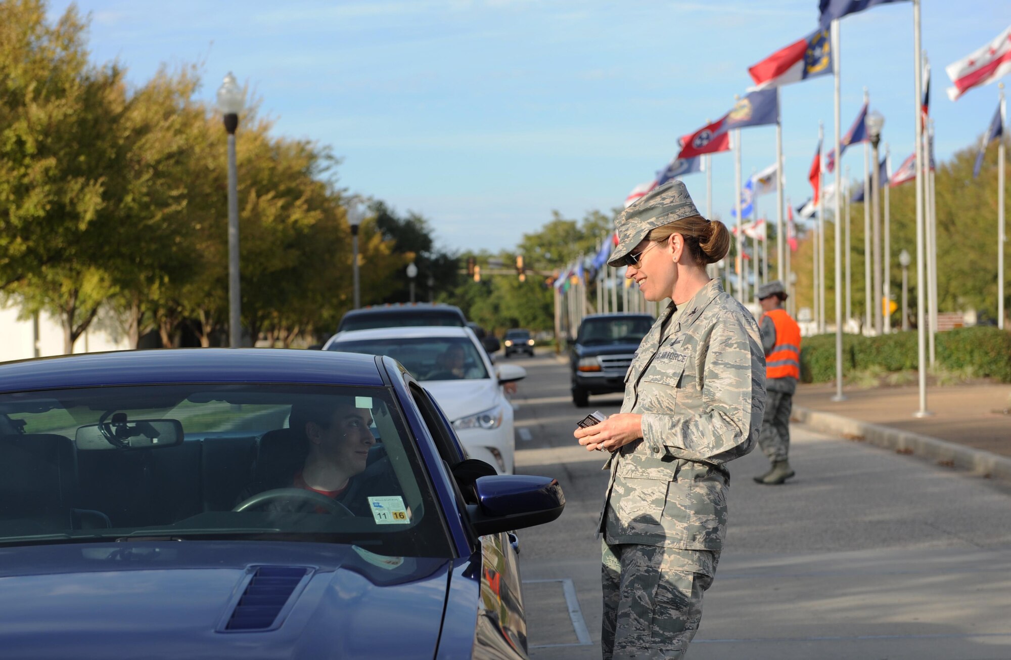 Col. Michele Edmondson, 81st Training Wing commander, delivers a holiday safety message to Senior Airman Mason Henry, 403rd Maintenance Squadron communications and navigations systems technician, as he departs the White Avenue gate Nov. 24, 2015, Keesler Air Force Base, Miss. Keesler leadership also passed out Airmen Against Drunk Driving cards to base personnel at all of the gates and reminded Airmen to ensure they stay safe this holiday weekend. (U.S. Air Force photo by Kemberly Groue)