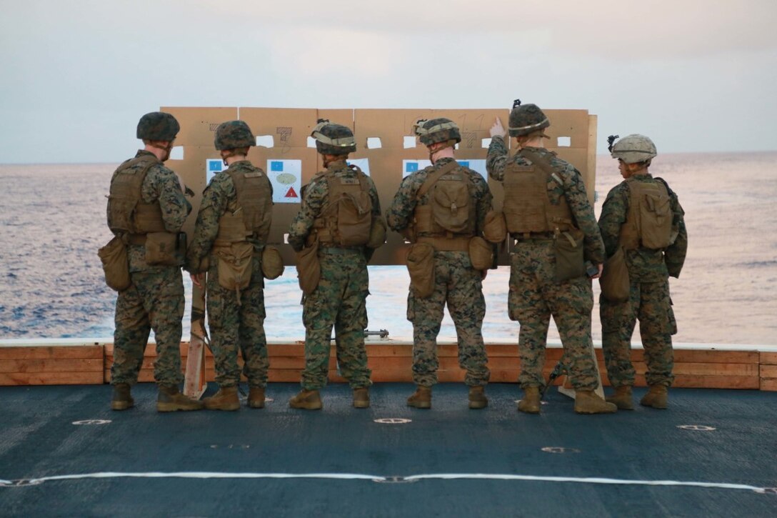 PHILIPPINE SEA (Nov. 24, 2015) U.S. Marines with 1st Light Armored Reconnaissance Detachment, Battalion Landing Team 3rd Battalion, 1st Marine Regiment, 15th Marine Expeditionary Unit, observe their shot groups on the flight deck aboard the USS Anchorage (LPD 23). The 15th MEU is currently deployed in the Indo-Asia-Pacific region to promote regional stability and security in the U.S. 7th Fleet area of operations. (U.S. Marine Corps photo by Sgt. Steve H. Lopez/Released)