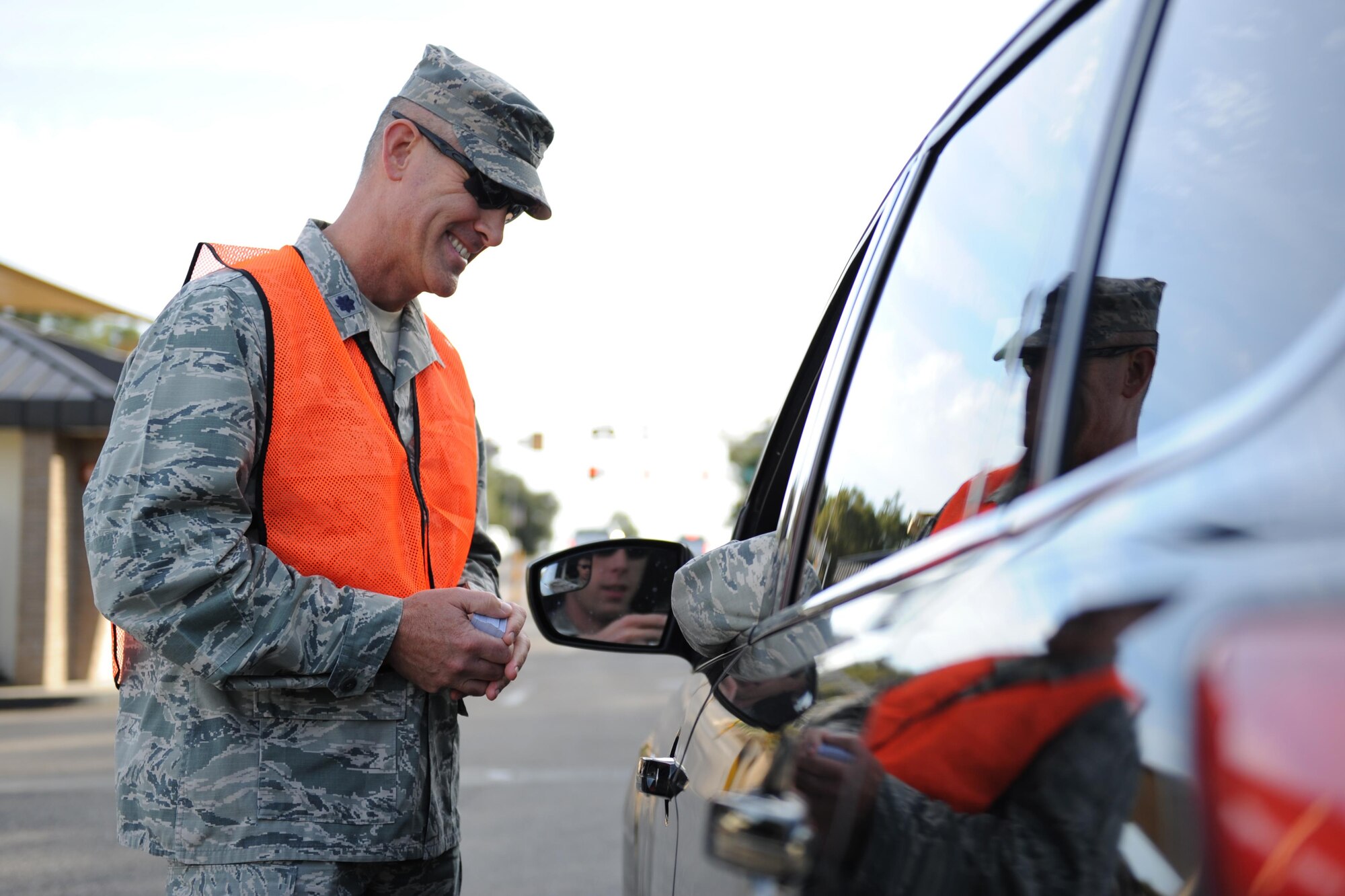 Lt. Col. David Young, 336th Training Squadron commander, delivers a holiday safety message to Staff Sgt. Tyler Kemplin, 333rd Training Squadron student, as he departs the White Avenue gate Nov. 24, 2015, Keesler Air Force Base, Miss. Keesler leadership also passed out Airmen Against Drunk Driving cards to base personnel at all of the gates and reminded Airmen to ensure they stay safe this holiday weekend. (U.S. Air Force photo by Kemberly Groue)