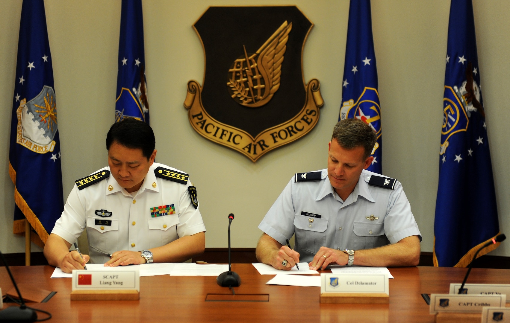 JOINT BASE PEARL HARBOR-HICKAM, Hawaii (Nov. 25, 2015) - U.S. Air Force Col. Brian Delamater, Chief of Pacific Air Forces Advanced and Warfighter Integration Division, and Senior Captain Liang Yang, Deputy Director Operations Department, Navy Headquarters, Peoples Liberation Army, sign the meeting minutes for the bi-annual Military Maritime Consultative Agreement (MMCA) talks, held Nov. 21-24, at Headquarters, Pacific Air Forces. The bilateral MMCA talks are a long-standing mechanism designed to provide open and transparent communication to address concerns and develop common understandings between U.S. and PRC air and naval forces in order to avoid unsafe incidents and minimize risk. (Photo by U.S. Pacific Air Forces Public Affairs)
