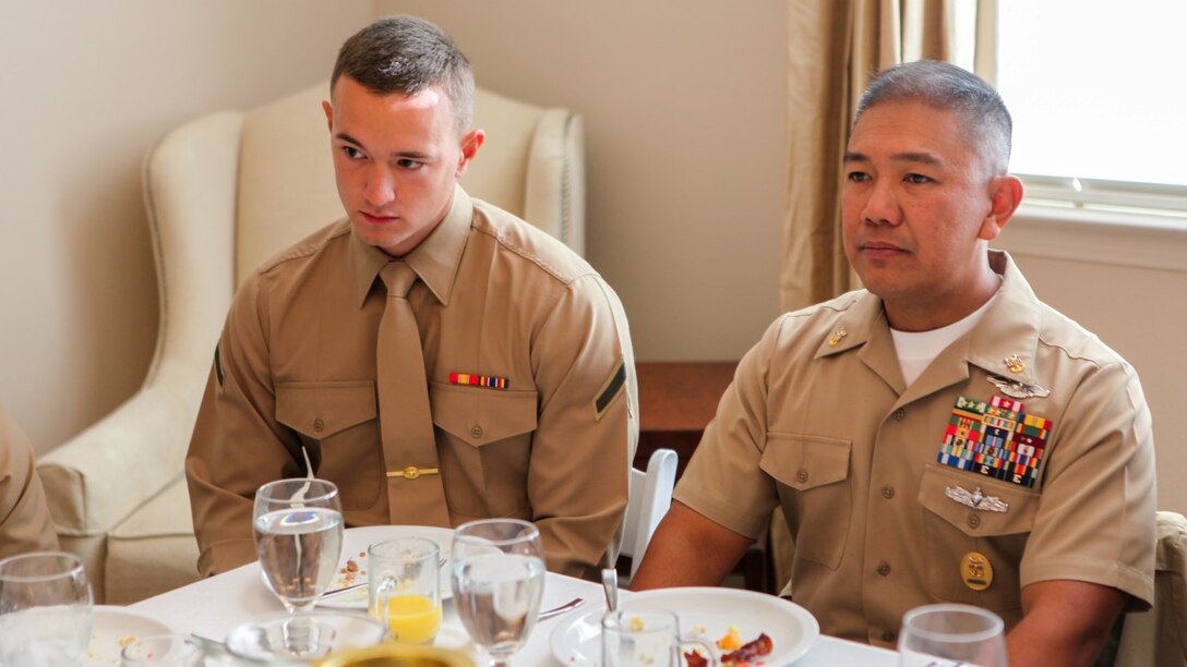 Master Chief Petty Officer Harlan Patawaran, the command master chief of 1st Marine Logistics Group, I Marine Expeditionary Force, and Pfc. Alex McClain, a bulk fuel specialist with 7th Engineer Support Battalion, 1st MLG, sit next to each other at an awards breakfast aboard Marine Corps Base Camp Pendleton, Calif., Nov. 20, 2015. At the awards breakfast senior leaders imparted words of wisdom and experience on their junior service members.