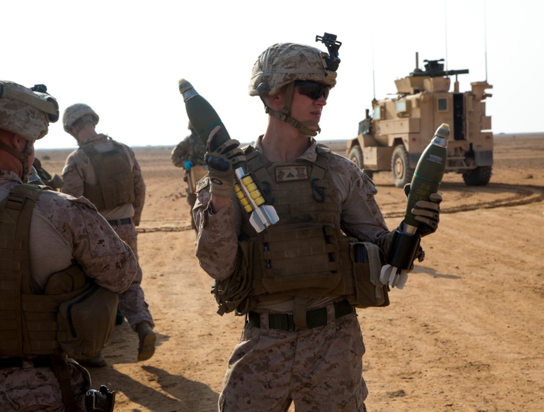 U.S. Marine Lance Cpl. Casey A. Schultz, a mortarman assigned to Weapons Company, 1st Battalion, 7th Marine Regiment, holds two 81mm high explosive (HE) mortars on a demolition range at Al Asad Air Base, Iraq, Nov. 9, 2015. Schultz helps prepare the mortars for a controlled detonation to rid these HE mortars that were deemed unserviceable by an ammo technician. 1/7 is the ground combat element of the Special Purpose Marine Air Ground Task Force - Crisis Response - Central Command, in support of Combined Joint Task Force – Operation Inherent Resolve. (U. S. Marine Corps photo by Staff Sgt. Nathan O. Sotelo/Released)